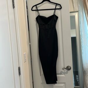 Silky black dress with a high slit. Midi length.